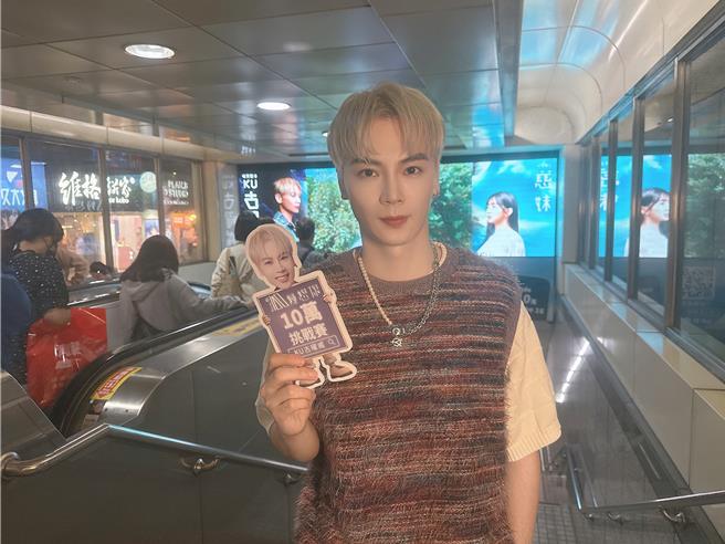 古曜威跟自己的看板合影。（经纪人提供）