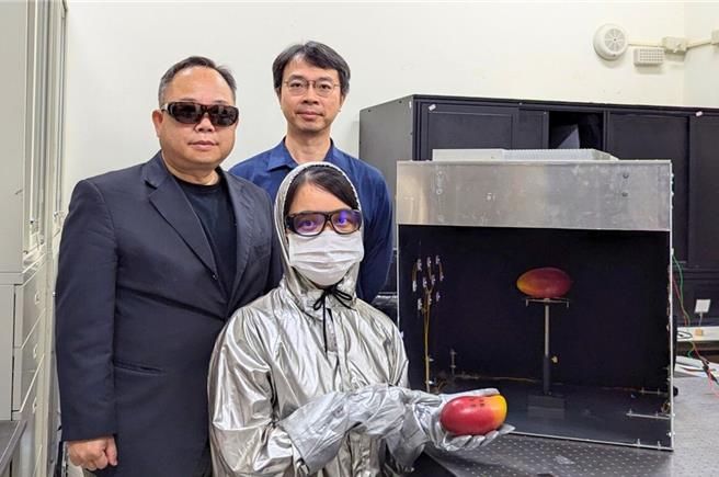 指導教授孫慶成（左）、光電系主任鄭恪亭（後）及博士生黎秋玉（前）與UVC照射箱。（中央大學提供）