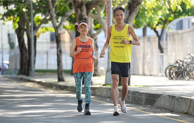 賴淑蘭老師（左）也是一位馬拉松跑者，在陪跑員的陪同下，透過路跑倡議平權。（興大提供／李京昇台中傳真）