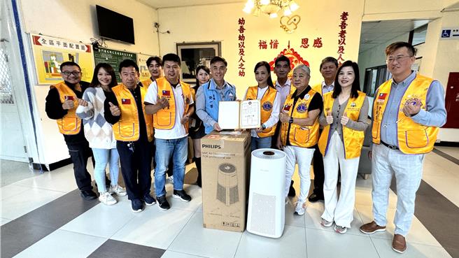金門金龍獅子會會長周曉芸(前排右四)今日帶隊前往大同之家捐贈一台空氣消毒機，為住民長輩們提供多一層健康保障。(于家麒攝)