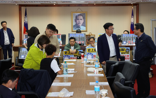 国民党立委许宇甄提案增订「罢免同意票须超过被罢免者当选票数」，事涉提高罢免门槛，蓝绿都发出甲级动员令。民进党立委们一进入会议室后，就先占据主席台，拿标语表达诉求。（刘宗龙摄）