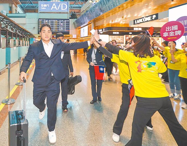 吉力吉捞．巩冠获免税店员工热情送机，亲切击掌回应。（陈麒全摄）