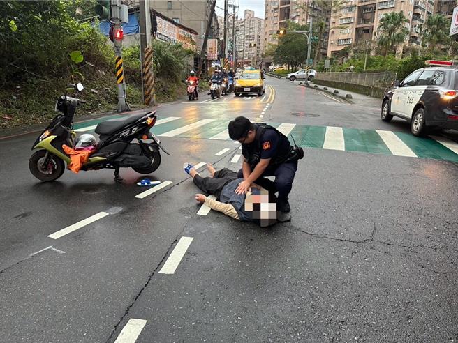 基隆一名吳姓79歲老翁於18日騎機車行經基隆市中正區新豐街、和豐街口時摔車還被機車壓在地面上動彈不得。警方巡邏發現老翁已無呼吸心跳，趕緊為老翁施作CPR，成功救回老翁一命。（基隆市警察局提供／徐佑昇基隆傳真）