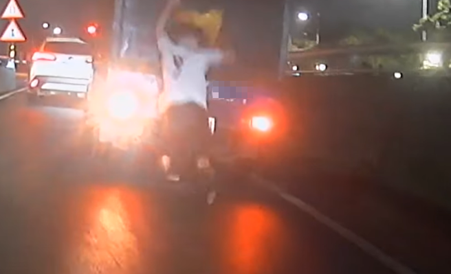 台北市中山區一名外國男子，吊掛在一輛行駛中的小貨車後方，還不斷拍打車頂，最後不慎踩空，整個人跌落在路中。（翻攝自WoWtchout - 地圖型行車影像分享平台）