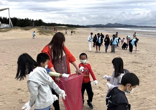 金门大学结合海洋保育目标，与贤庵国小共同组织学生和地方居民在后湖海滩展开了一场有意义的净滩活动。（图／金门大学）
