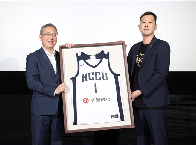 永丰银行与政大雄鹰篮球队启动三年赞助合作计画，雄鹰篮球队执行长孙秉宏（右）致赠纪念球衣，由永丰银行总经理庄铭福（左）代表接受。（永丰提供）