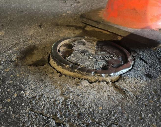 桃园市芦竹警分局芦竹交通分队警员日前执行巡逻勤务，行经南工路时，发现一自小客车，故障停在路边，员警见状上前关心，柯姓女驾驶向员警表示车辆行经南工路与芦兴街口时，压过人孔盖而爆胎，员警随即前往该处查看，发现该路口有一处人孔盖疑似遭车辆辗压而与基座分离，为避免后续往来人车发生危险，员警立即以胶布将人孔盖黏贴固定，避免车辆辗压而弹开，并通报相关单位到场维修。（翻摄照片）