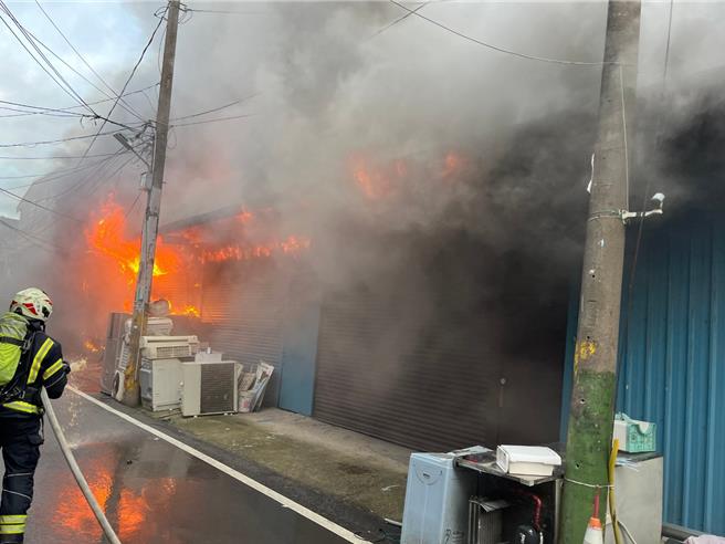 桃园市八德区高城二街今天清晨发生火警，一处连栋铁皮结构建筑物起火，消防局赶往救援，虽冒出大量浓烟，所幸无人员受伤受困，目前残火处理中。（翻摄照片）