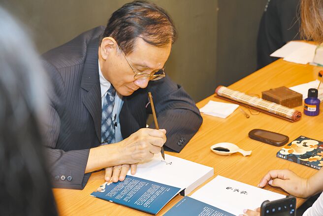 林水福教授在分享會現場為讀者揮毫簽名。（聯經出版提供）