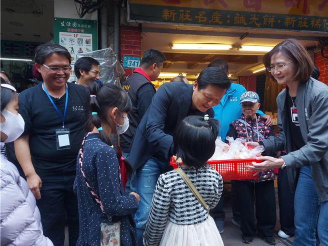 新北市副市长朱惕之和文化局长张䕒育在新庄老街发送咸光饼。（张铠乙摄）