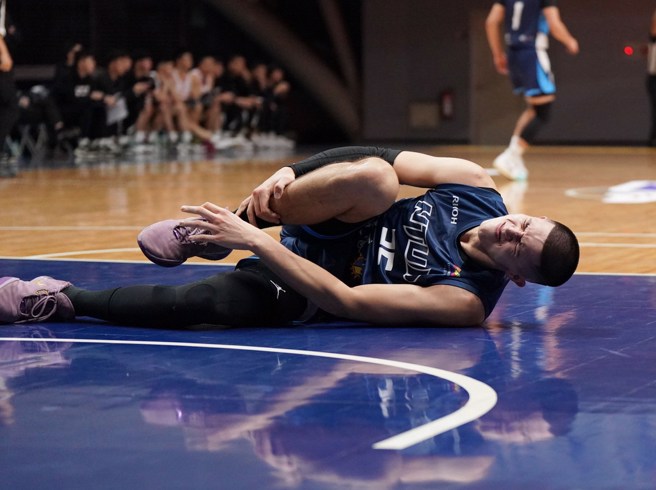 梁瀚倒在地上抓住脚踝痛苦不已。(大专体总提供)