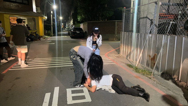 男大生酒精路跑喝倒到ㄎㄧㄤ掉，不僅倒臥馬路上還大聲喧嘩，甚至變身喪屍要咬友人耳朵。（翻攝畫面）