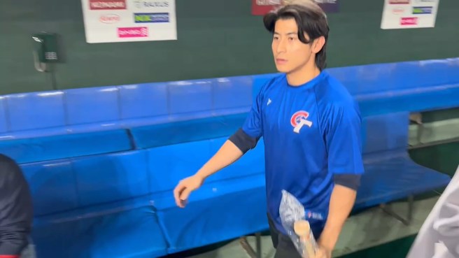 台湾队长陈杰宪拿两支球棒，跟小园海斗进行友好交换。（翻摄画面）