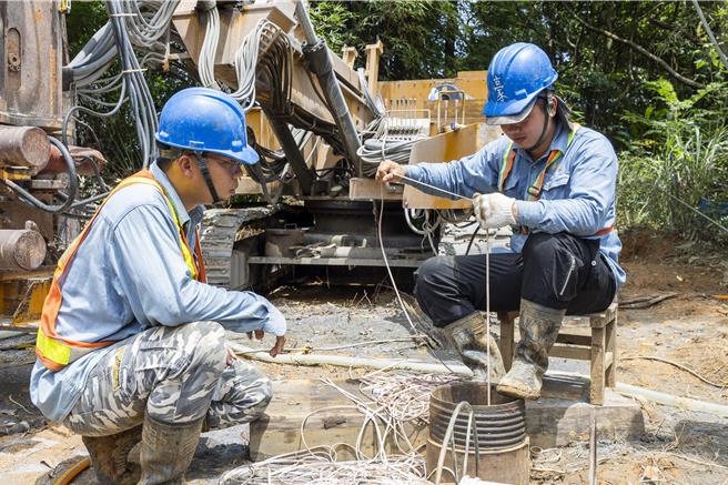 施工人员量测凿井钻掘深度。（新北市水利局提供）