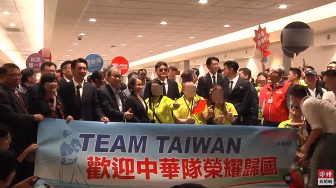 穿着黄色上衣的免税店员工挤进中华队合照，引爆球迷不满。（翻摄自中时新闻网YouTube）