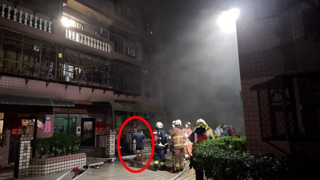 屋主（红圈）一开始发现火警企图灭火，发现无果后立即逃出，消防队到场扑灭火势。（翻摄画面）