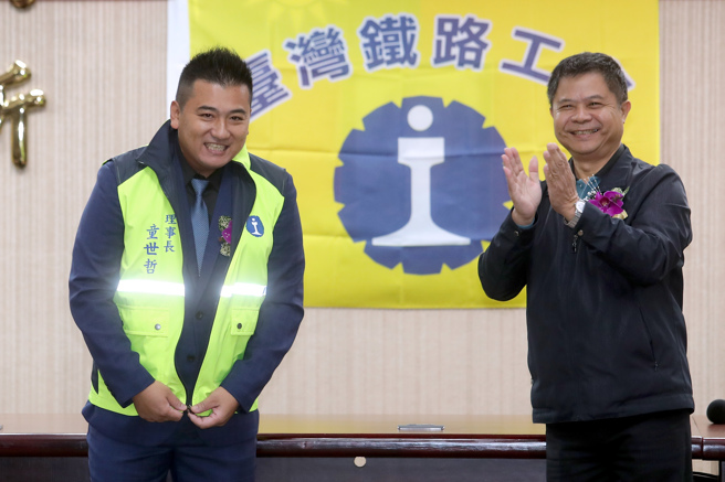 台灣鐵路企業工會27日舉行新卸任理事長交接典禮，卸任理事長陳世杰（右）將理事長職銜背心交給新任理事長童世哲（左）。（黃世麒攝）