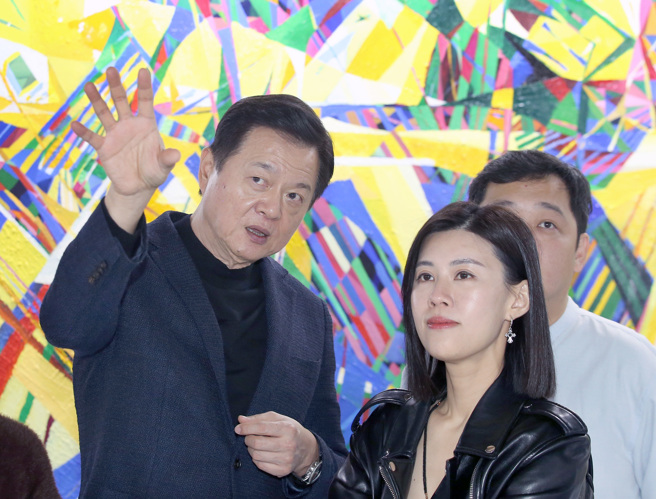 旺旺集团副董事长周锡玮（左）的「一合相」画展27日在松山文创园区一号仓库盛大开幕，并亲自为参观民眾讲解画作。（范扬光摄）