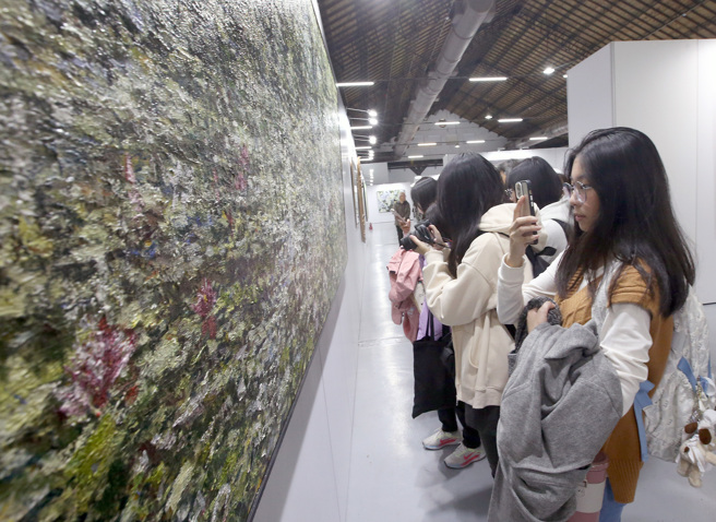 旺旺集团副董事长周锡玮的「一合相」画展27日在松山文创园区一号仓库盛大开幕，吸引大批民眾参观。（范扬光摄）