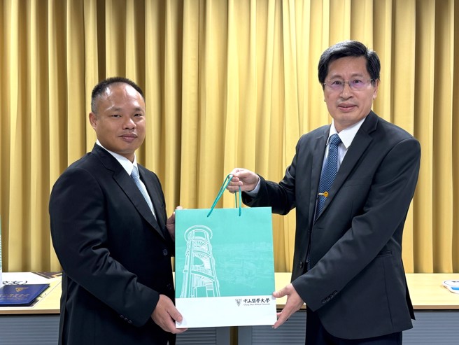 中山医大医科院长余丰益(右)感谢立富畜牧场负责人刘芸富的慷慨捐赠。（照片/中山医学大学提供）