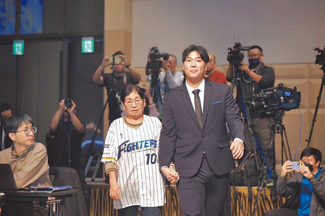 統一獅強投古林睿煬轉戰日本職棒北海道火腿鬥士隊，球團特地打造「溫馨金孫風」，古林（右）與阿嬤牽手入場。（啟程國際運動行銷提供／黃邱倫台北傳真）
