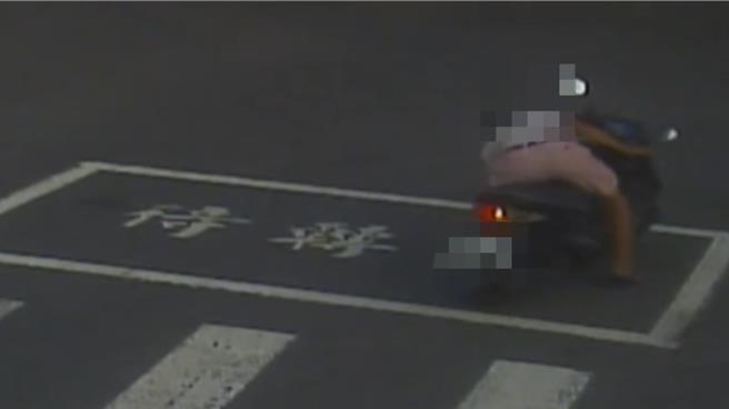 路口监视器拍下，阿伯在待转区等红灯时，弯腰捡东西，结果不慎催到油门自摔。（翻摄画面／纪爰高雄传真）