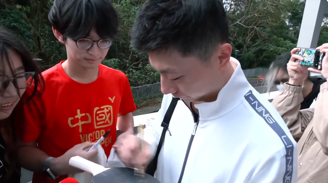 大陆桌球名将马龙28日随陆生团参访政治大学，不少学生拿出球拍要签名。(翻摄自中时新闻网直播)