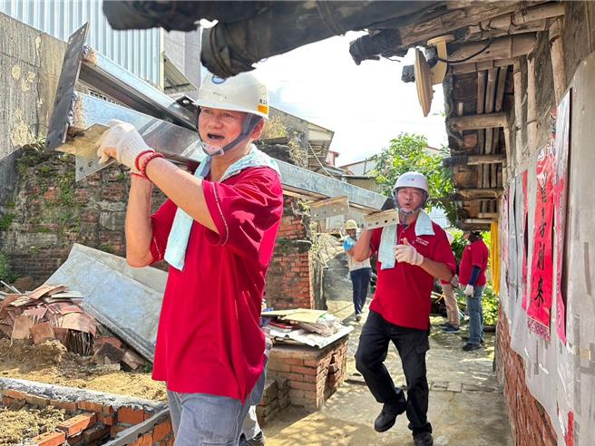 台南市劳工局劳安福利科长吴素珍近期拍摄志工徒手扛钢材的影像，获台南市社会局所举办的志工服务摄影奖佳作肯定。（台南市劳工局提供／张毓翎台南传真）