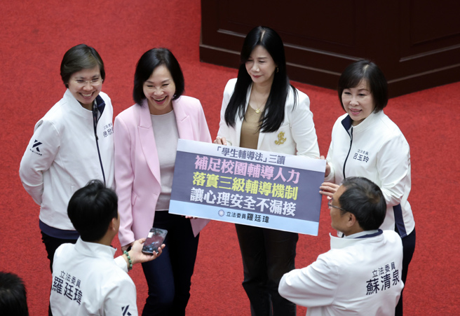 立法院29日院会三读通过「学生辅导法」部分条文修正草案，立委吕玉玲（后排右起）、万美玲、柯志恩、徐欣莹等人在议场内拿着标语合影。（姚志平摄）