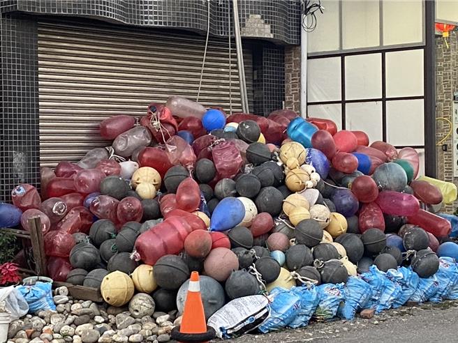 創造「石頭屋」的劉姓屋主日前因病過逝，其生前所收集的彩色浮球仍保留，整齊堆置屋外並置放三角錐圍起、目前沒有丟棄。（張妍溱攝）