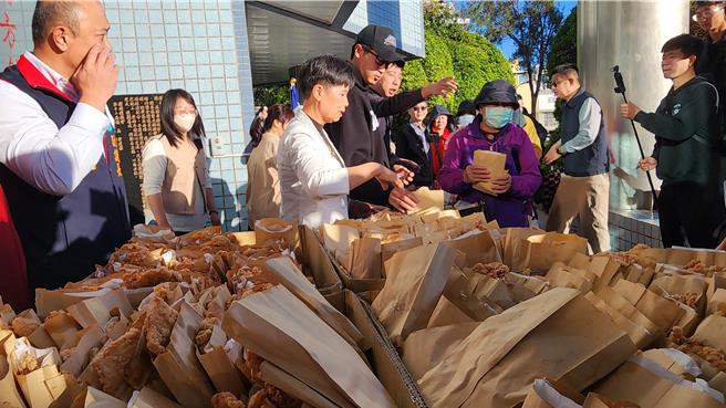 「拆弹眼镜哥」庄昕谚和澎议长陈毓仁在议会门口分鸡排给排队民眾。（许逸民摄）