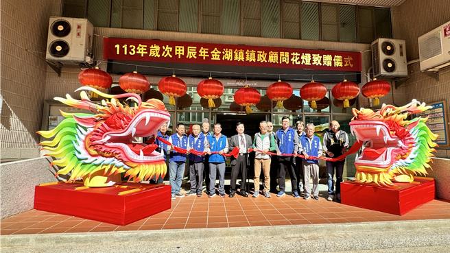 由金门县金湖镇镇务顾问龚秦裕(中)捐赠的一对「龙尾年」花灯华丽陈设于镇公所大门两侧，昨日选定良辰吉时隆重举行花灯揭彩与开灯仪式，打造金湖观光新亮点。(图／金湖镇公所提供)