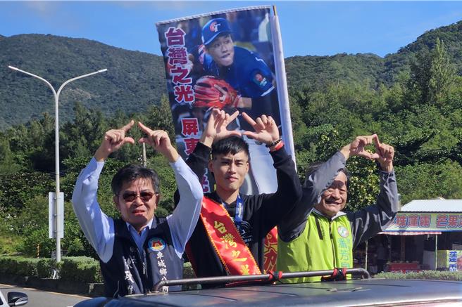 中華隊內野手張政禹（中）回到車城老家，與車城鄉長陳政雄（左）、屏東縣議員潘芳泉（右）同車遊行。（羅琦文攝）