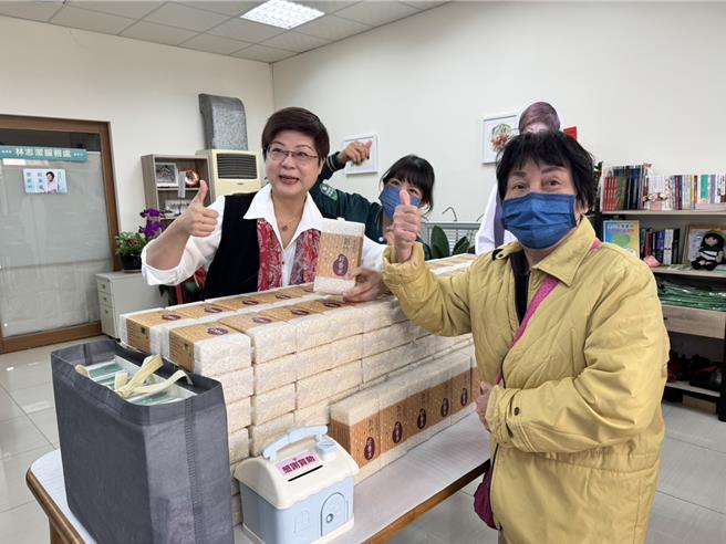 中华队在世界12强棒球锦标赛夺冠，阳明交大科技法律学院特聘教授林志洁，11月30日在服务处发放新竹小农香米，义卖所得的现金和发票捐赠给家扶基金会、球芽基金会。（王惠慧摄）