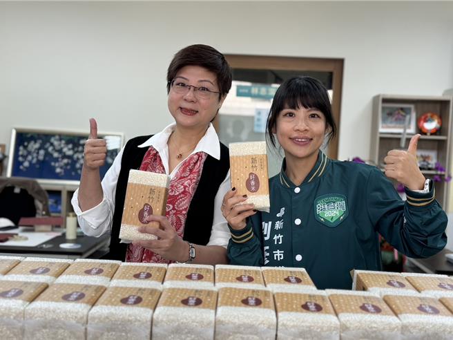 阳明交大科技法律学院特聘教授林志洁（左）11月30日在服务处发放新竹小农香米。（王惠慧摄）