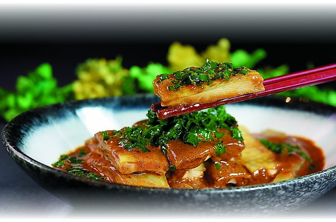 〈芥末韭香雞〉是以「怪味醬」為雞腿肉提味，雞腿上方是以熱油澆淋過的韭菜末，襯底的是芥末醬調味的粉皮。圖／姚舜、國賓中餐廳