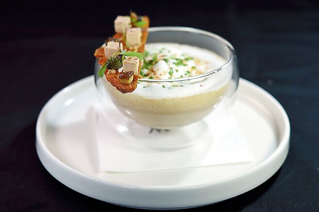 台北W饭店的现代法式餐厅〈Seasons by olivier e.〉的耶诞跨年套餐中的〈栗子浓汤／鹅肝／炭烤蘑菇／卡布奇诺〉，未添加任何水、高汤或淀粉，仅以来自法国的栗子、鲜奶与香草籽经黄金比例熬煮浓郁汤底，添加炭烤后切丁的蘑菇、顶层铺上以咖啡机打出的滑顺奶泡。图／姚舜