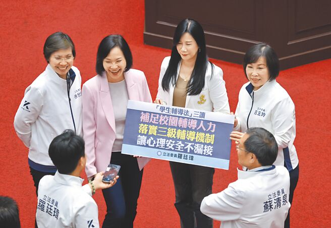 立法院院会29日三读通过《学生辅导法》修正草案，立委吕玉玲（后排右起）、万美玲、柯志恩、徐欣莹等人在议场内拿着标语合影。（姚志平摄）