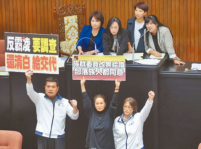 立法院29日院会处理「原住民族委员会组织法」部分条文修正草案时，国民党提议停止讨论，爆发民进党立委陈莹（上排左二）等人衝上台杯葛并霸占主席台，立委高金素梅（下排左二）则高举「族群委员改无给职，部落人都同意」标语反制并表达立场。（资料照／姚志平摄）