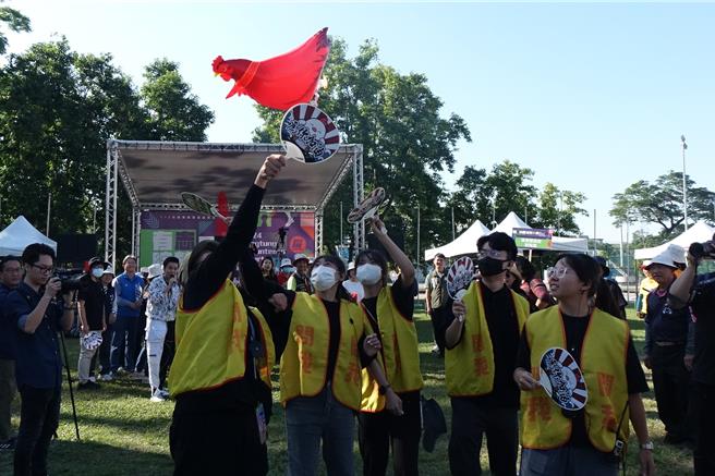 屏东县国际志工日运动大会由「咕咕鸡赛跑」揭开序幕，大家拿扇子将公鸡气球扇在空中往终点跑。（罗琦文摄）
