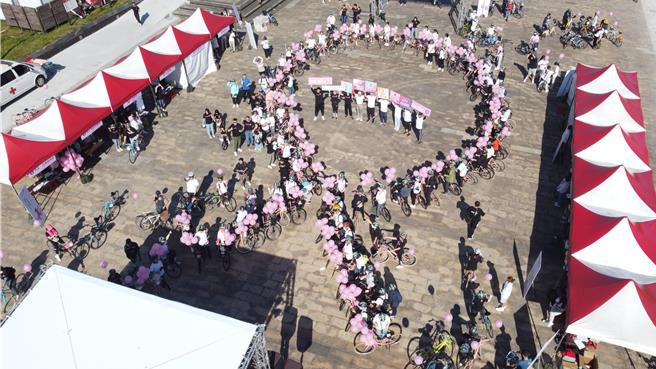 台湾癌症基金会首度集合百台粉红脚踏车，排列巨型粉红丝带造型，呼吁多多关心身边女性，乳癌预防人人有责。（台湾癌症基金会提供）