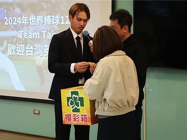 张毅抽出20名幸运儿，并为球迷在棒球上签名。（叶静美摄）