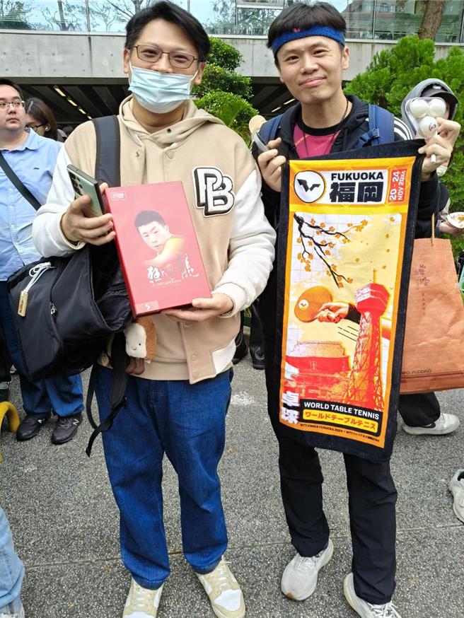 兩名上班族今天特地請假，準備了馬龍紀念球拍、桌球等應援配備前來，希望能給馬龍簽到名。(李侑珊攝)