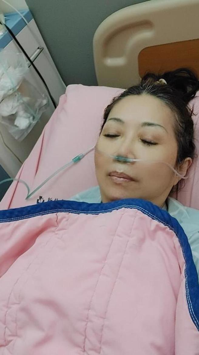 刘明珠拿出先前肺炎住院奄奄一息的照片给美国海关检视。（刘明珠提供