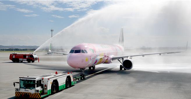 长荣航空第二架全新彩绘机「粉萌机」4日正式亮相首航仙台，机场公司特地举行洒水礼致意。（范扬光摄）