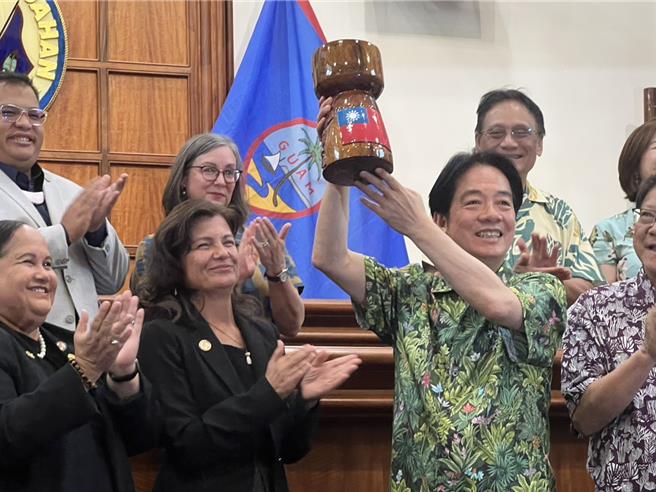 关岛议会赠木制品，赖清德高举仿陈杰宪这个动作。（曾薏苹摄）