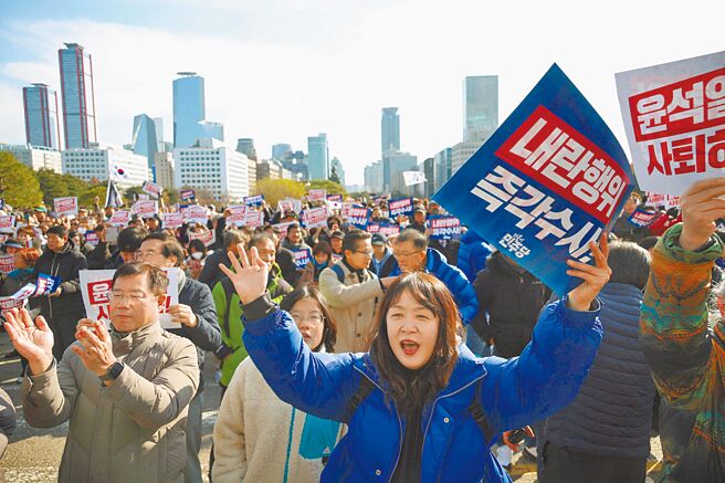 韩国首尔民眾4日在国会集会上举着写着「总统尹锡悦下台」和「立即调查他的叛乱行为」的标语牌，谴责韩国总统昨晚突然宣布戒严并要求他辞职。（路透）
