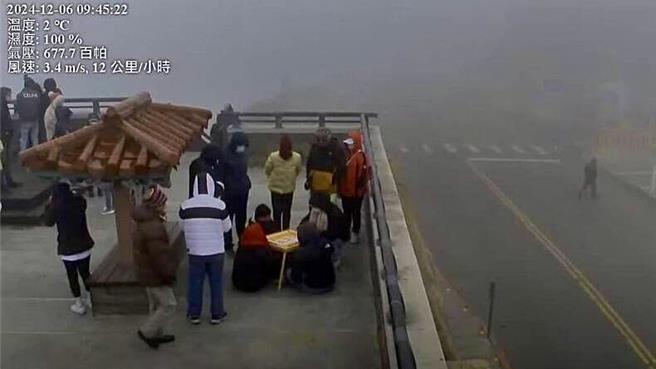 眼尖网友透过公路局即时影像，赫见4个人在合欢山武岭亭摆起小方桌打麻将，过程吸引游客观战。（翻摄公路局合欢山武岭亭即时影像／杨静茹南投传真）