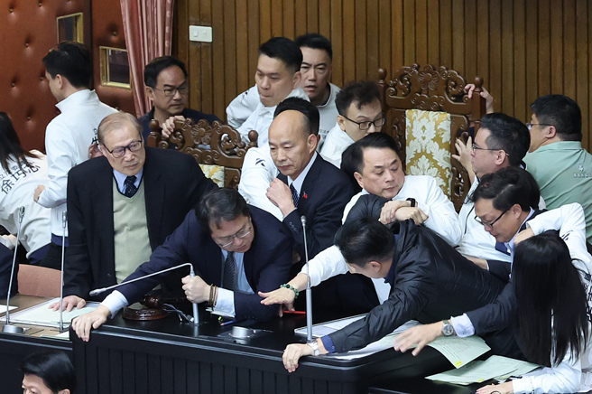立法院6日院会，国民党提出变更议程案，欲将「选罢法」修正案排入议程，民进党立委趁机衝上主席台杯葛议事，国民党立委立即上前保护院长韩国瑜并抢回主席台，蓝绿爆发拉扯推挤衝突。（资料照/姚志平摄）