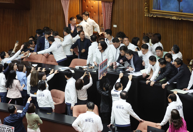 立法院6日院會，國民黨提出變更議程案，欲將「選罷法」修正案排入議程，民進黨立委趁機衝上主席台杯葛議事，國民黨立委立即上前保護院長韓國瑜並搶回主席台，藍綠爆發拉扯推擠衝突。（姚志平攝）
